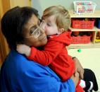 Carter Haas, 18 months, give his classroom foster grandmother, Idella Williams, a kiss during class Jan. 11 at Children's Village Early Learning Center, a part of Lutheran Social Services of Indiana, 6613 South Anthony Blvd.