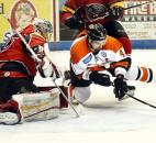 Komets defenseman Scott Kishel, right, delivers a diving shot as he floats in front of Cincinnati goalie Brian Foster during the overtime period Jan. 13 at Memorial Coliseum. Kishel's shot glanced off the goal post, but shortly afterward, teammate Mike Hoban, not pictured, beat Foster with a wrist shot, giving the Komets a 3-2 win.