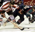 Colin Chaulk checks Port Huron's John Vary during the first period in a 2004 game at the coliseum. (File photo by Ellie Bogue of The News-Sentinel)