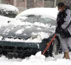 Jami Fitzgerald of Indiana Avenue digs out her car as she prepares to get in one more grocery store run Sunday. (Photo by Ellie Bogue of The News-Sentinel).