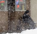 Despite the heavy snow a patron of O'Sullivan's on Main Street was sitting out front Sunday afternoon.(Photo by Ellie Bogue of The News-Sentinel).