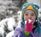 Cadee Ross, 4, found the snow more interesting to eat than to build snowmen out of Sunday. She along with her two sisters were enjoying the snow. The Ross family lives in the 700 block of West Wildwood Avenue. (Photo by Ellie Bogue of The News-Sentinel).