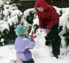 Ezree Ross, 12, puts the finishing touches on her snowman with a little help from her sister Cadee Ross, 4, Sunday afternoon. The girls, along with sister Ivey, 9, were having fun in the snow, before the intense cold that was to follow Monday and Tuesday. The girls live in the 700 block of West Wildwood Avenue. (Photo by Ellie Bogue of The News-Sentinel).