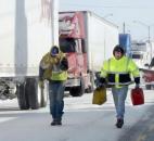 Below zero temperatures, blowing snow and closed down roads have left about 200 truckers stuck at the Fort Wayne Truck Plaza, 3037 Goshen Road. Hailing from Bellamy, Wash., driver Brian Wilson, right, had run his truck out of fuel and was stuck on Coliseum Boulevard along with a whole line of trucks that couldn't make it into the truck stop because it was full. He was preparing to get fuel and some help to restart his rig. (Photo by Ellie Bogue of The News-Sentinel).