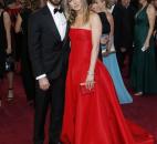Actors Justin Theroux, left, and Jennifer Anniston arrived together at the Oscars, with Anniston wearing a Valentino red strapless gown. (From The Associated Press)