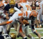 Columbus East 's Markell Jones rockets over the pack to escape being tackled during the second half of play. 
