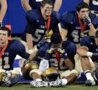 Players wait in the end zone for the team group photo after receiving their runner up medals.