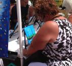 Kim Corya paints her first canvas piece of art at the Art in the Park as part of the Three Rivers Festival. The session, put on by Wine & Canvas, was free to participants. (Photo by Jaclyn Goldsborough)