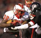 North Side’s Anthony Linnear, left, busts through the arm-tackle attempt of Bishop Luers linebacker Jaylon Smith during Friday’s game at Luersfield. The Knights held on for a 22-20 victory after North Side failed on a two-point conversion after Linnear scored a touchdown in the final minute of play. (By Chad Ryan of INMedia Source)