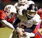 Heritage lineman Landon Ternet, left, drops Garrett quarterback Noah Follett for a loss in Friday'a game at Heritage. Photo by Chad Ryan