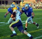 Carroll’s Ross Koble, No. 6, and Justin Tranquill converge to take down Goshen running back Mason Bechdolt. (By Blake Sebring of The News-Sentinel)