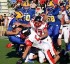 Homestead quarterback Matt Skowronek gets tackled by Huntington North’s Taylor Boxell, bottom, Matthew Mounsey, No. 47, and Nathan Sutter, No. 54, early in the second quarter Friday night. (By Blake Sebring of The News-Sentinel)