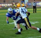 Carroll’s Ryan Achor tackles Goshen’s Mason Bechdolt. (By Blake Sebring of The News-Sentinel)
