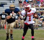 North Side quarterback C.J. Jackson takes off on a second-quarter scramble as Bishop Dwenger’s Ian Barton tries to close in for a tackle. (Photo by Blake Sebring of The News-Sentinel)