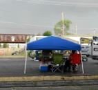 Vendors of the Historic West Main Street Farmers Market scramble to keep their canopy from blowing over moments before a fast-moving storm hit Friday afternoon. The National Weather Service reported wind of 63 mph with gusts at Fort Wayne International Airport of 91 mph. (By Lisa Esquivel Long)