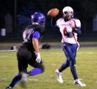 Heritage quarterback Connor Sheehan looks for an open receiver against the rush of Leo’s Nolan Wilson. (By Blake Sebring of The News-Sentinel)
