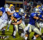Homestead’s Nicholas Hitner and Elijah Zavala, left, drag down Carroll’s Jimmy Crumley during the second quarter Friday night. (By Blake Sebring of The News-Sentinel)