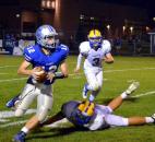 Carroll quarterback Chris Terry stuttersteps along the sideline as he avoids the tackle of Homestead’s Elijah Zavala to keep a play alive and throw for a first down. (By Blake Sebring of The News-Sentinel)
