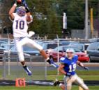 Homestead’s Seth Coate leaps to make a first-quarter catch against the defense of Carroll’s Sam Dunn. (By Blake Sebring of The News-Sentinel)