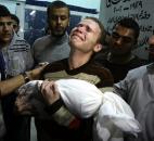 Jihad Masharawi weeps while he holds the body of his 11-month old son Ahmad after an Israeli air strike on their family house in Gaza City. The Israeli military and Hamas battled for eight days in November, leading to numerous civilian casualties. Photo by The Associated Press