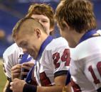 Logan Dorman looks at his Class 2A football championship medal after Bishop Luers beat Monrovia for the 2009 state title at Lucas Oil Stadium in Indianapolis. Bishop Luers overcame a three-point halftime deficit with 10 points in the third quarter to win its first of three consecutive state championships. (File photo by Ellie Bogue of The News-Sentinel)