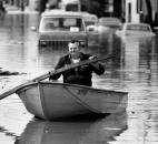 Using a board as a paddle, a Fort Wayne resident floats through the Nebraska neighborhood.