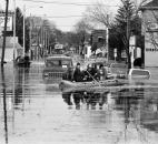 Rescuers take flooded West Main Street residents to dry land on March 14. The view is from the West Main Street bridge looking west.