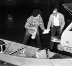 Residents transfer salvaged items from their canoe to a vehicle during a late-night evacuation.