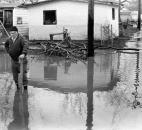 George Brinkman, of 4017 Elm St., one of the first residents back in the area, works to clear a drain. Soon after the photo was taken, Brinkman succeeded and the water disappeared down the sewer.