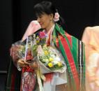 Aung San Suu Kyi gathers her gifts as she prepares to sit down Tuesday morning before her address in front of a crowd of 5,125 at Memorial Coliseum. By Ellie Bogue 
