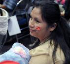 Mar Mar Lwin holds her sleeping 1-year-old daughter as she waits for Nobel Peace Prize winner and world leader Aung San Suu Kyi to speak Tuesday at Memorial Coliseum. By Ellie Bogue 