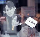 People press masks of Nobel Peace Prize winner Aung San Suu Ky against the glass as they wait for the doors of Memorial Coliseum to open early Tuesday morning. By Ellie Bogue 