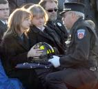 Janet Haudenschild receives the helmet of her late husband, Washington Township volunteer and assistant chief engineer Mark A. Haudenschild II, during his burial Saturday at Riverview Cemetery. Making the presentation is Washington Township Assistant Fire Chief Bruce McBride. Photo by Ellie Bogue