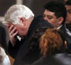 After approaching the caskets, Bishop John D'Arcy stops to pray for mother Ana Casas Rios and daughters Liliana Karen, 10, Kathy, 4, and Thannya, 1, in December 2005. News-Sentinel file photo