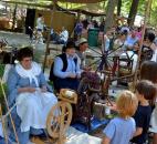 Weather was good for this year's Johnny Appleseed Festival in September, drawing large crowds. Here a group of children watch and talk with settlers spinning yarn. Photo by Sarah Janssen