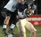 Bishop Dwenger's Keenan Centlivre makes the catch, but is pulled down by Concord's Dallas Maynard, who had been attempting to intercept the pass in the first quarter of the game against Concord Friday night. Photo by Ellie Bogue
