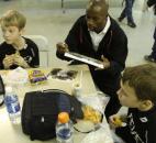 Clayton, 10, left, and Colin, 10, right, have lunch with DaMarcus Beasley as he autographs some pictures during a break in Tuesday's session of the Beasley National Soccer School holiday camp for children at The Plex South.