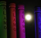 A hazy supermoon is seen behind lighted smoke stacks Saturday night at the Alamo Quarry Market in San Antonio.  