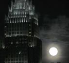 A full moon rises beside the Bank of America corporate headquarters Saturday in downtown Charlotte, N.C.