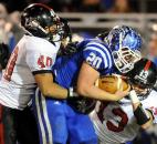 Bishops Luers Aaron LaMasters (40), left and Matt Williamson (13) try to bring down Tipton's Jamers Altherr during regional football action Friday evening at Tipton. Photo by Rob Edwards