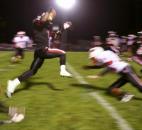 Bishop Luers’ Michael Rogers, center, leaps through the diving tackles of North Side’s Latavion Guy, left, and Lucas Braun en route to a punt returned for a touchdown in the Knights’ 22-20 win over North Side on Friday at Luersfield. (By Chad Ryan of INMedia Source)