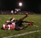 North Side’s Anthony Linnear, front, rolls into the end zone as he tackled by Bishop Luers’ Matt Williamson in the final minute of play during Friday’s game at Luersfield. Linnear’s touchdown pulled North Side to within two points of the Knights, but the Redskins’ two-point conversion attempt failed, and Bishop Luers’ closed the game with a 22-20 victory. (By Chad Ryan of INMedia Source)