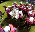 The Heritage Patriots carry their victory bell to midfield to celebrate their 56-2" win over Garrett in the regular-season finale on Friday at Heritage. Photo by Chad Ryan