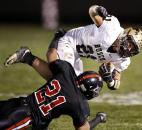 Bishop Luers defensive back Andrew Spencer, bottom upends Churubusco running back Jason Nicodemus during the second half of the Knights' 21-0 win over Churubusco in their Class 2A sectional championship game on Friday at LuersField. Photo by Chad Ryan
