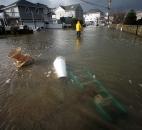A man walks through floodwaters in the aftermath of Sandy on Tuesday, in Milford, Conn. Sandy, the storm that made landfall Monday, caused multiple fatalities, halted mass transit and cut power to more than 6 million homes and businesses. Photo by Brian A. Pounds