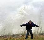 Hilavio Baquero stands in front of waves as winds from Hurricane Sandy reach Seaside Park in Bridgeport, Conn., on Monday. 