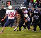 Heritage defenders Zach Toles, No. 2, and Cole Gerardot, No. 9, wrap up Leo junior running back Logan Leiter. (By Blake Sebring of The News-Sentinel)