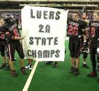 Bishop Luers players hold up a homemade championship banner on the field of the RCA Dome after defeating Southridge 36-30 in the 2002 Class 2A state finals in Indianapolis. Running back Jhormy Martinez led Bishop Luers with 148 rushing yards on 32 carries and scored two touchdowns as the Knights won their second consecutive state championship. (News-Sentinel file photo)