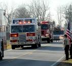 Boy Scouts from Churubusco, stood beside Carroll road near the entrance to the Riverview Cemetery Saturday as the parade of Fire trucks, and the one carrying Washington Township volunteer and assistant chief engineer Mark A. Haudenschild II body passed by. Photo by Ellie Bogue