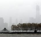 One World Trade Center, right, peeks through a light rain as water from the Hudson River creeps up on Pier A Park with the expected arrival of Hurricane Sandy in Hoboken, N.J., on Monday. 